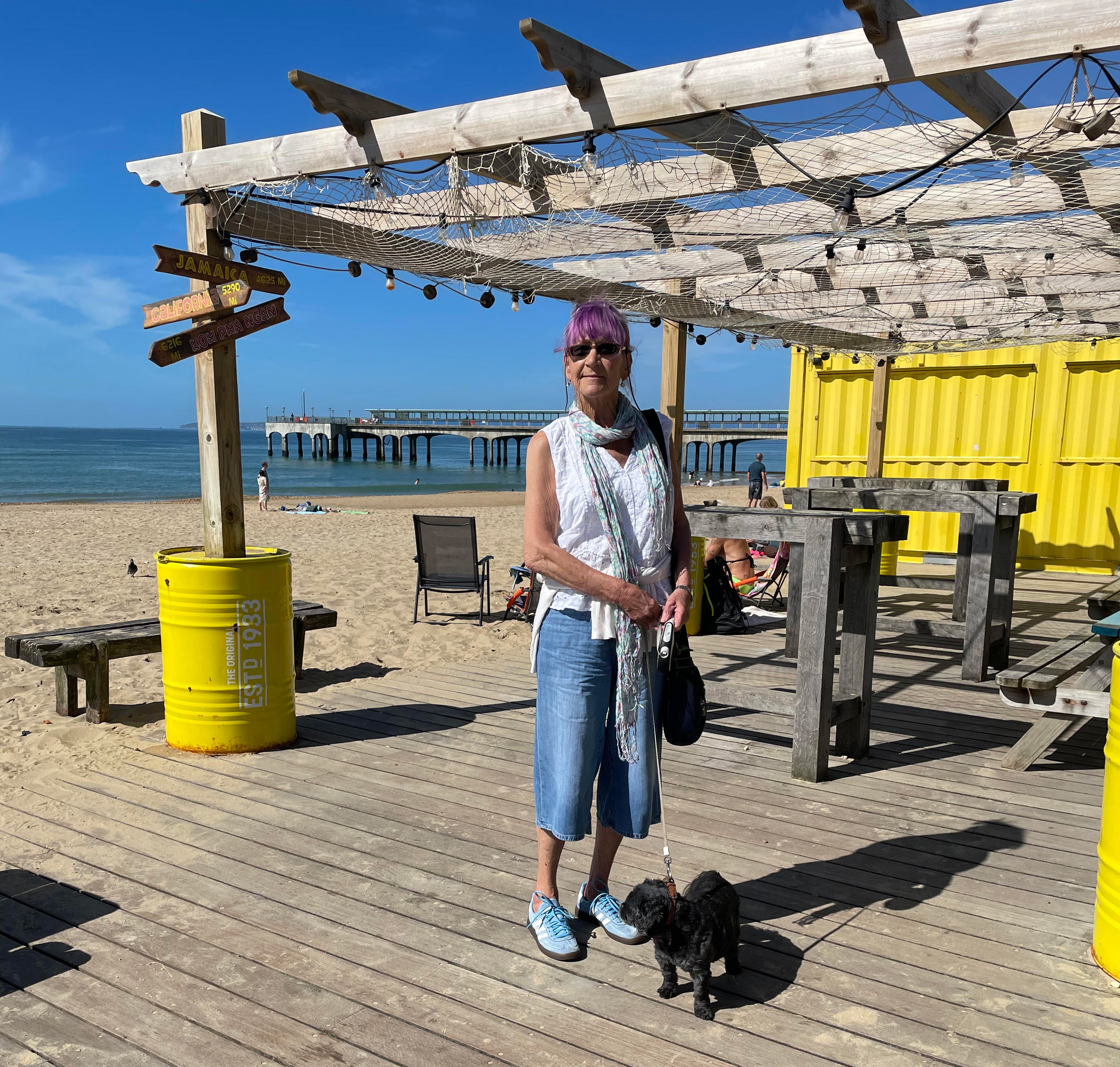 Lady on a sunny day at the beach with her dog