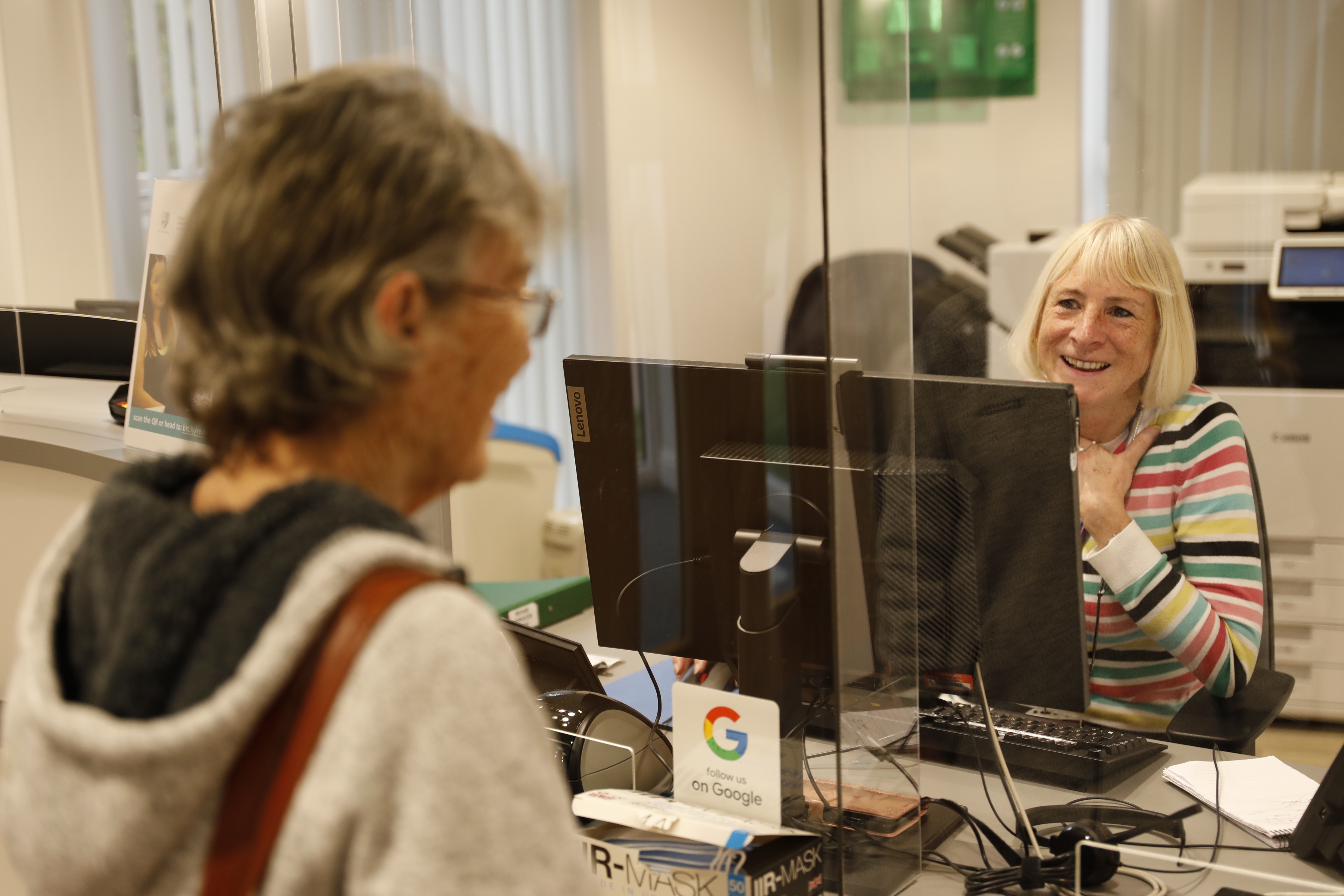 Friendly receptionist helping a patient check in at the IRC