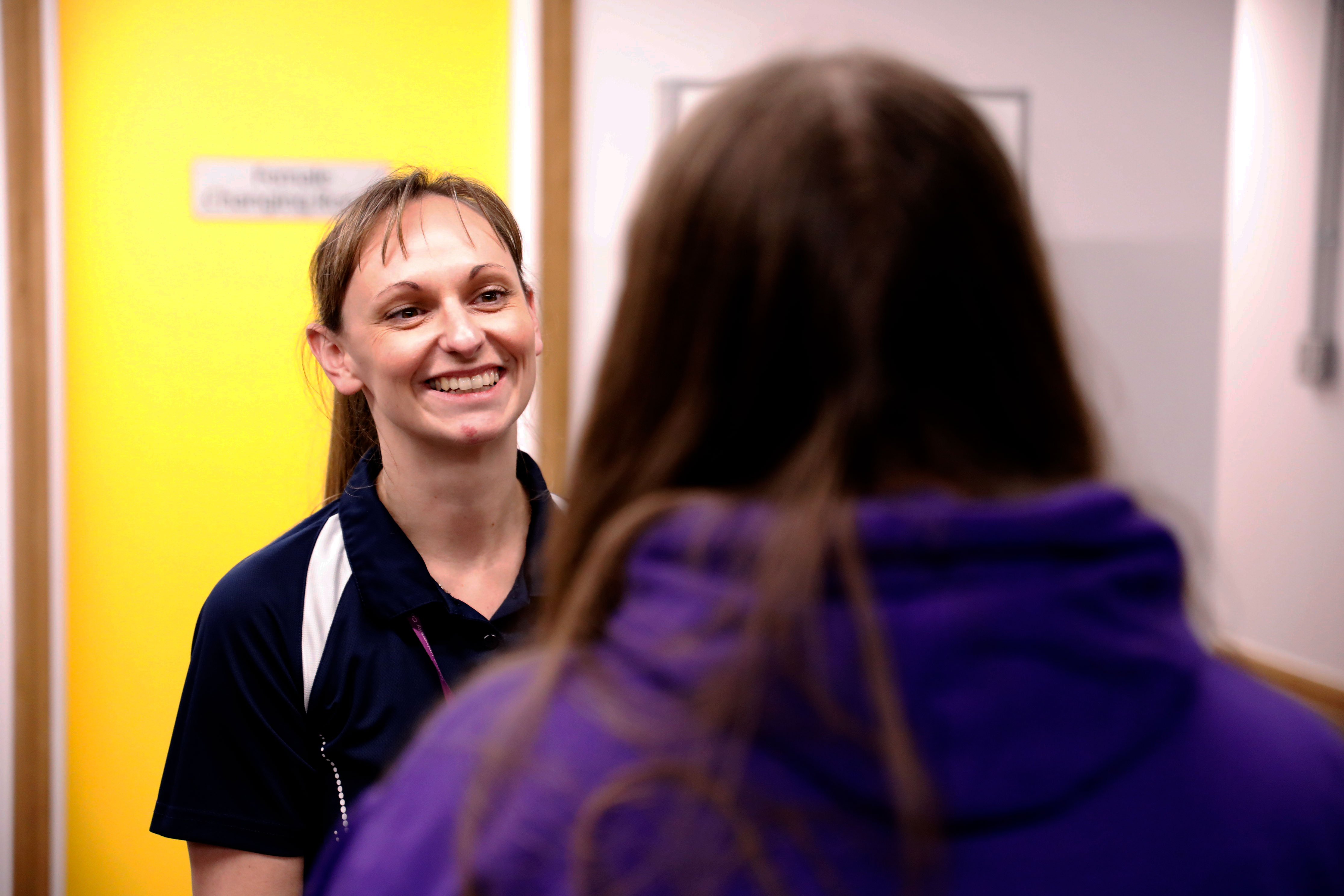 over the shoulder photo of clinician speaking with her patient