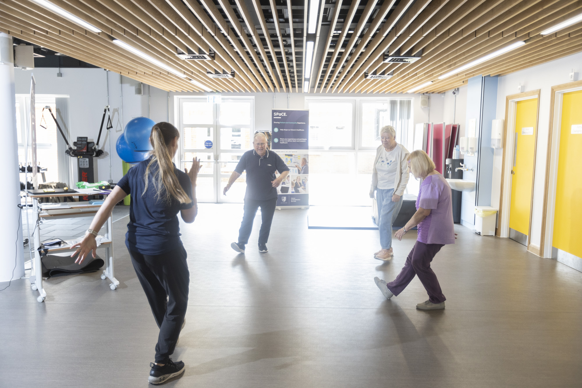 exercise class with three patients led by a physiotherapist