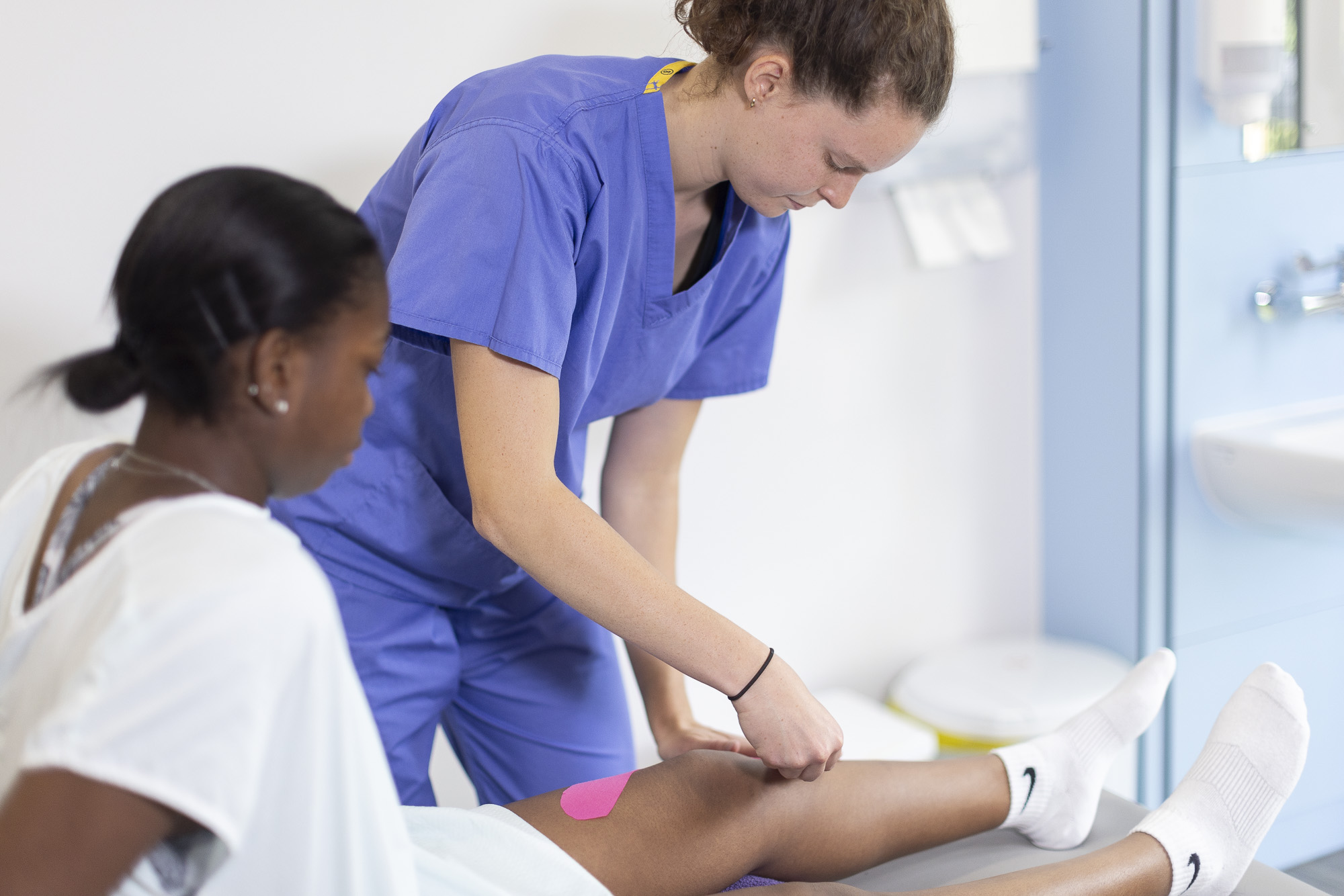 young female patient during physical assessment with her clinician