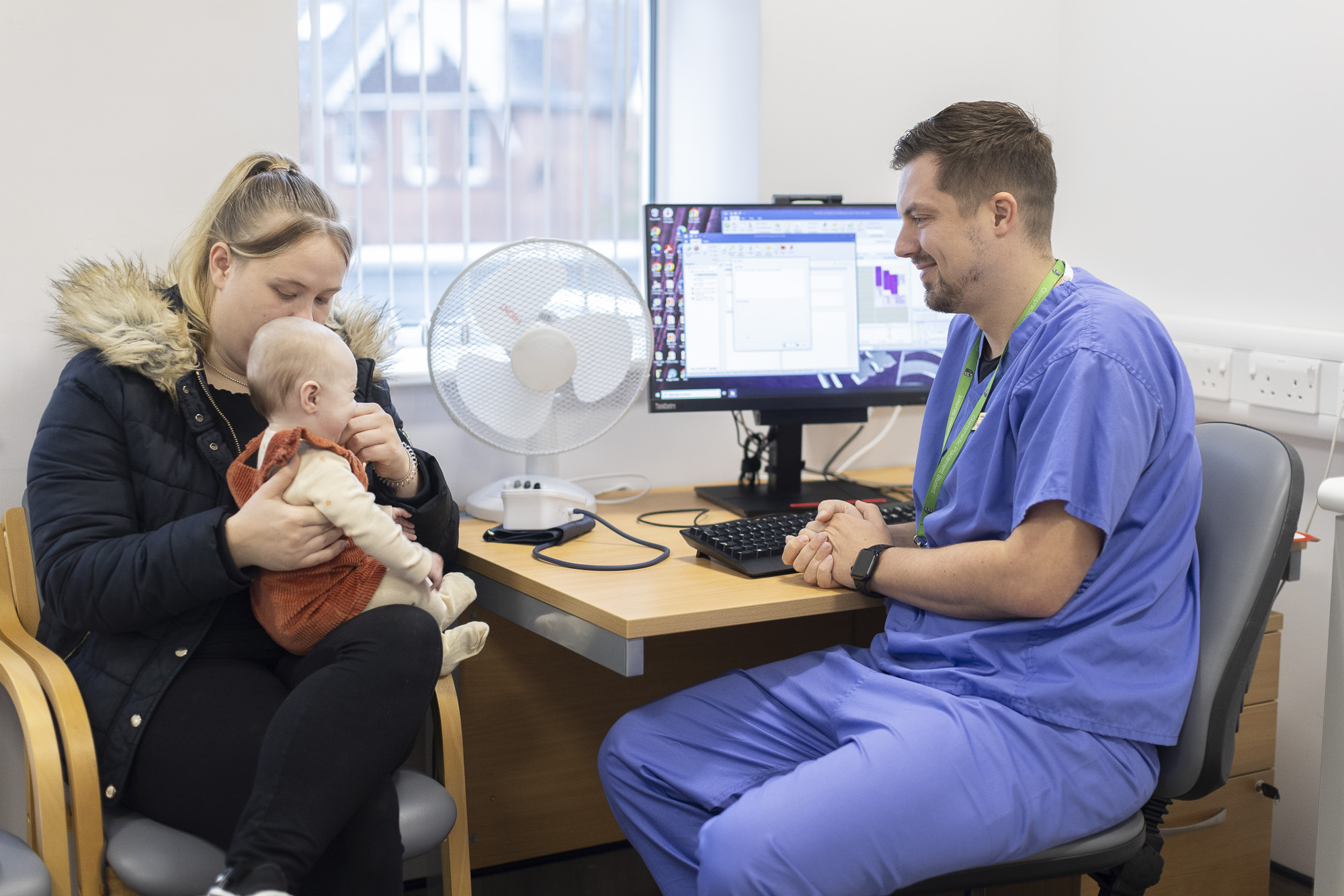 Mother, child and placement chiropractic student in a treatment room during paediatric clinic appointment