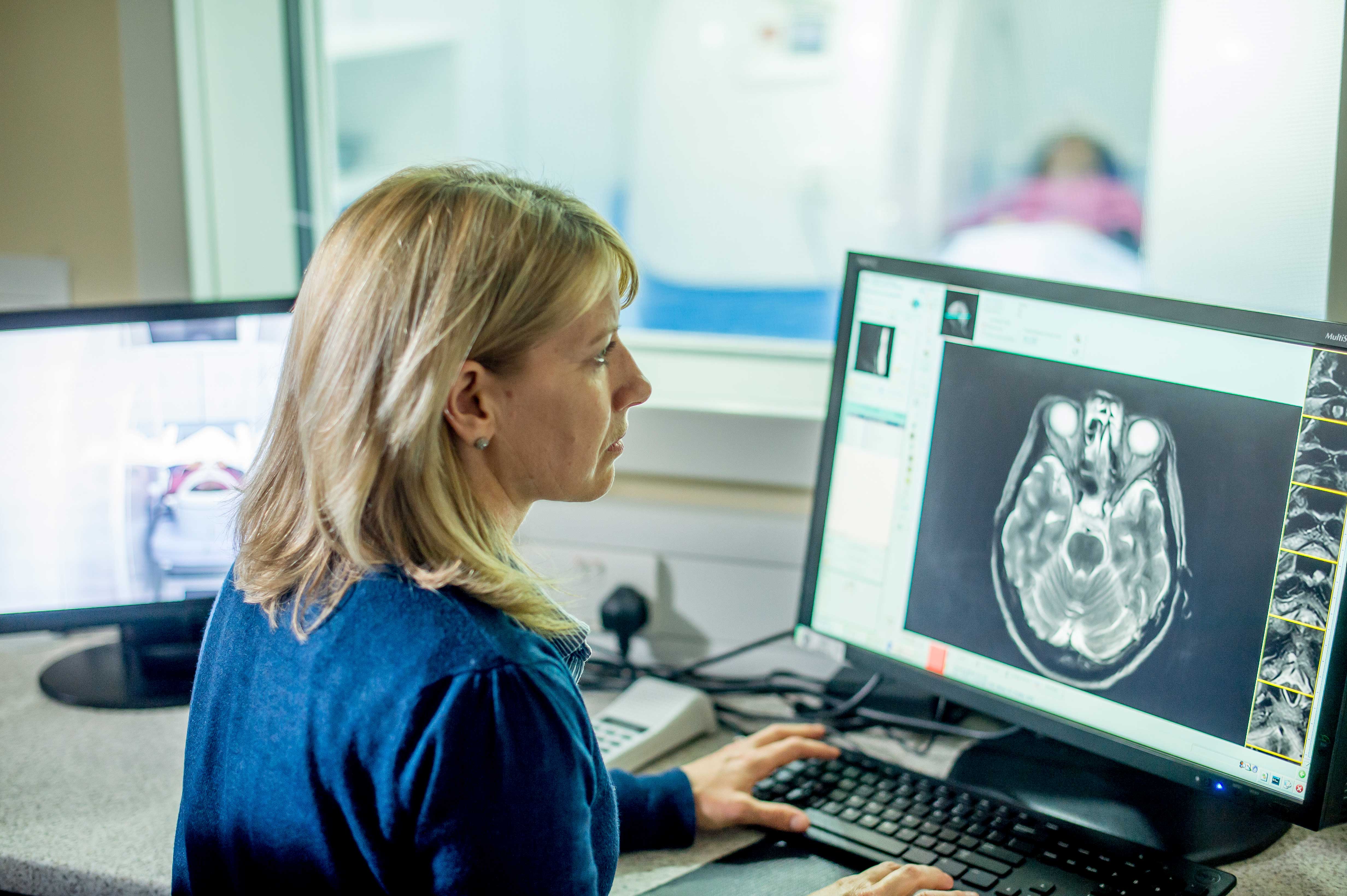 Clinician reading an image of a brain scan during an MRI