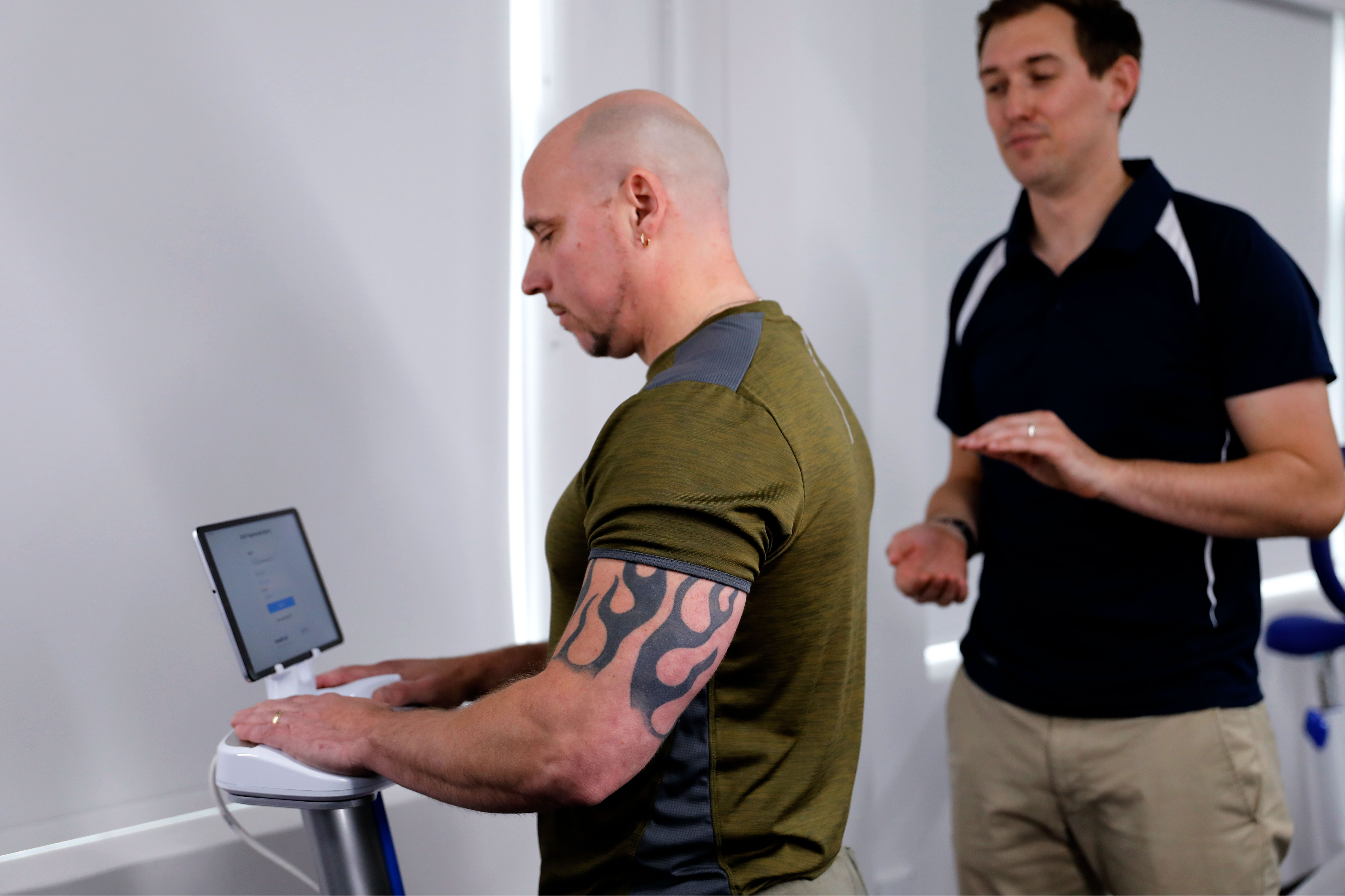 physiotherapist calibrating exercise equipment for his patient