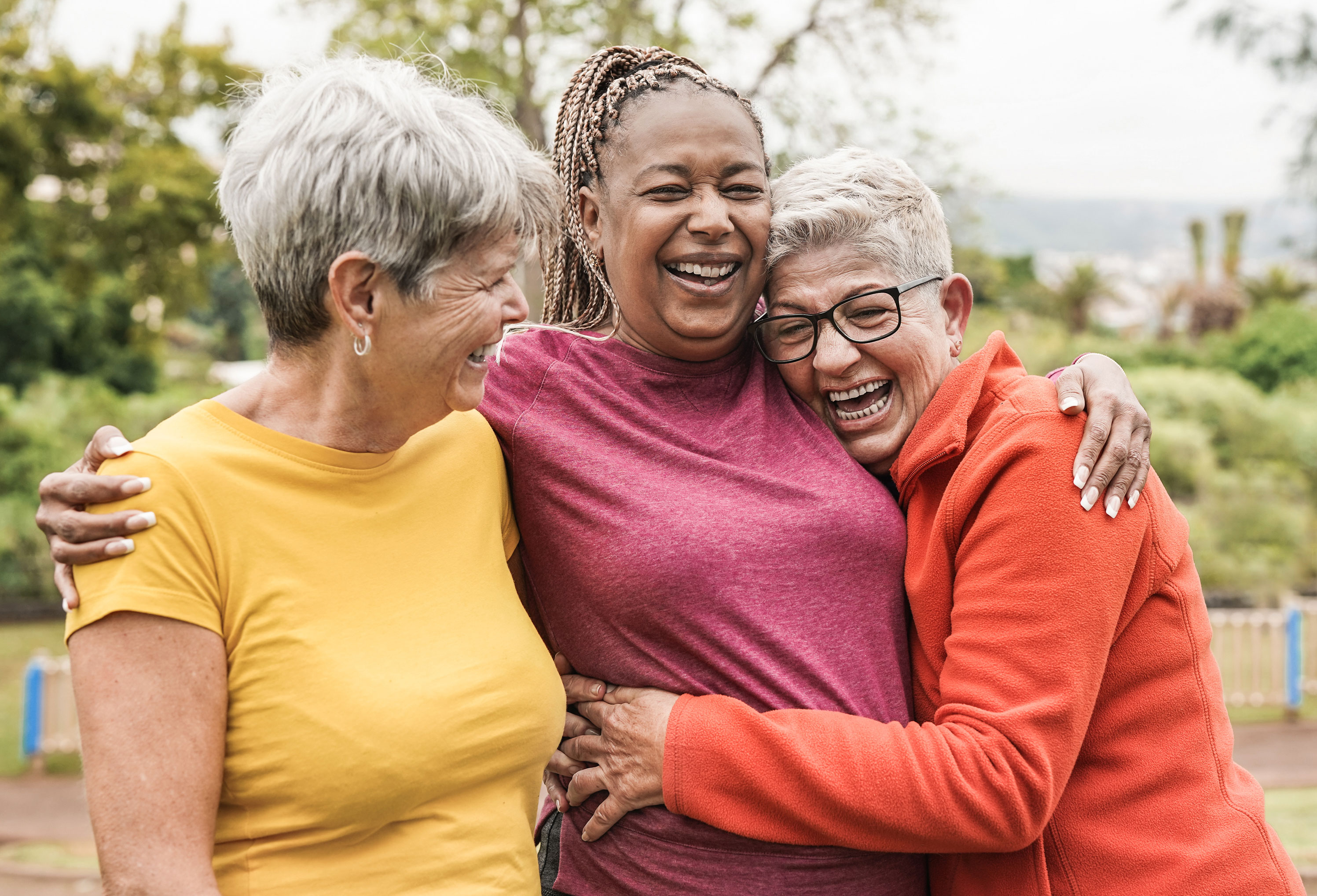 three females in an embrace, facing the camera