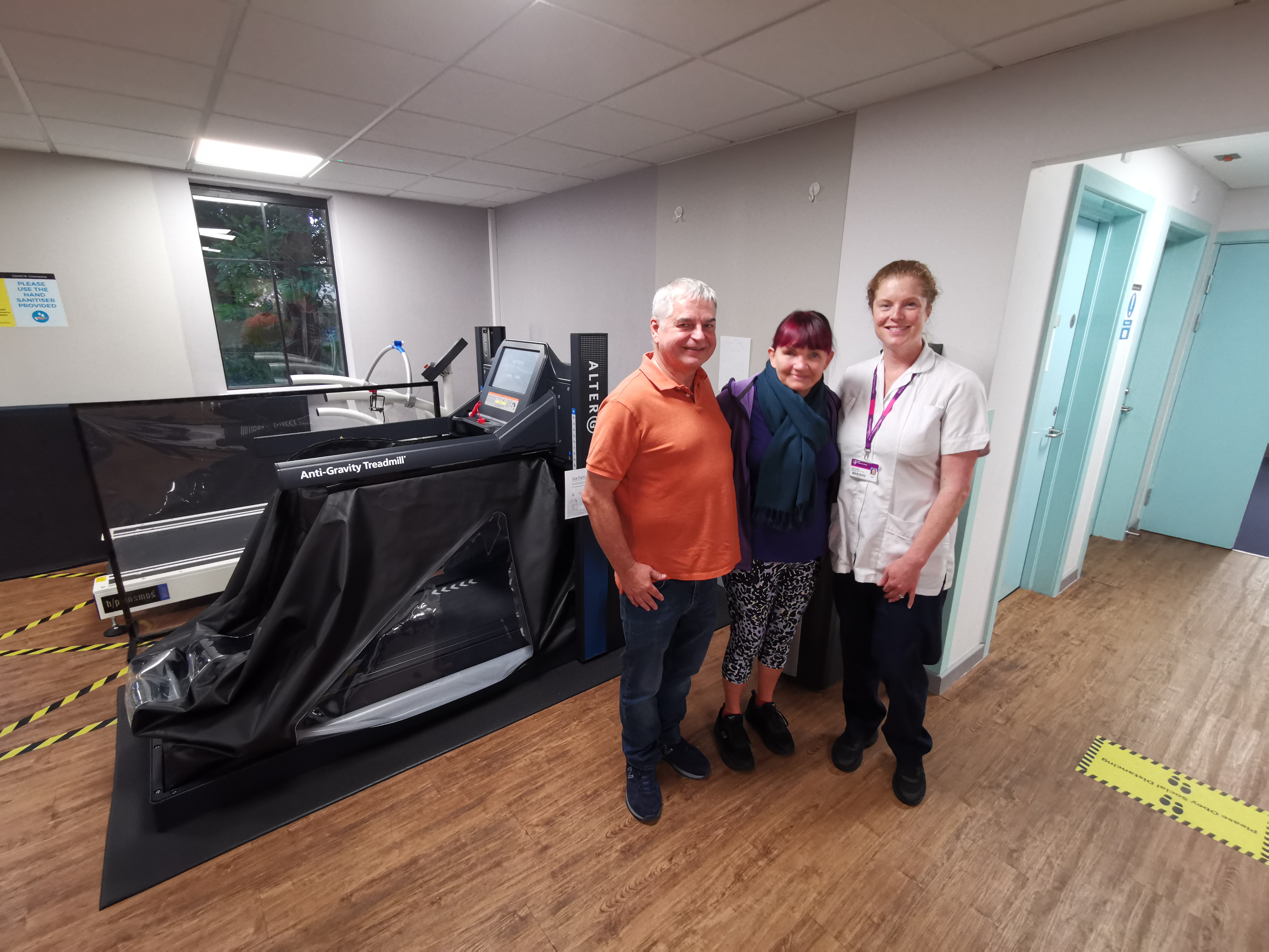 patients and their neurological physiotherapist posing next to Anti-Gravity treadmill