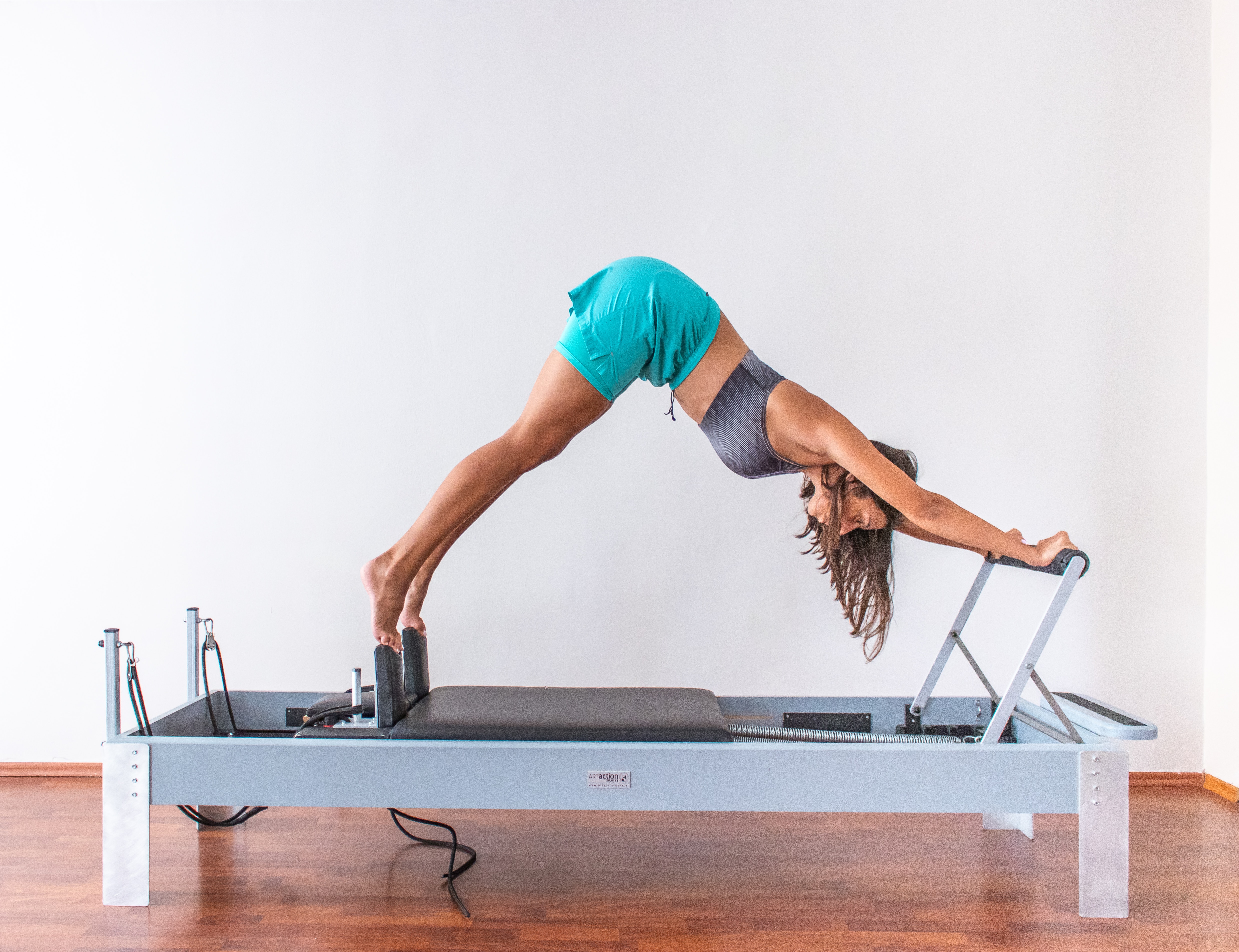 young woman performing stretches on an elevated exercise frame