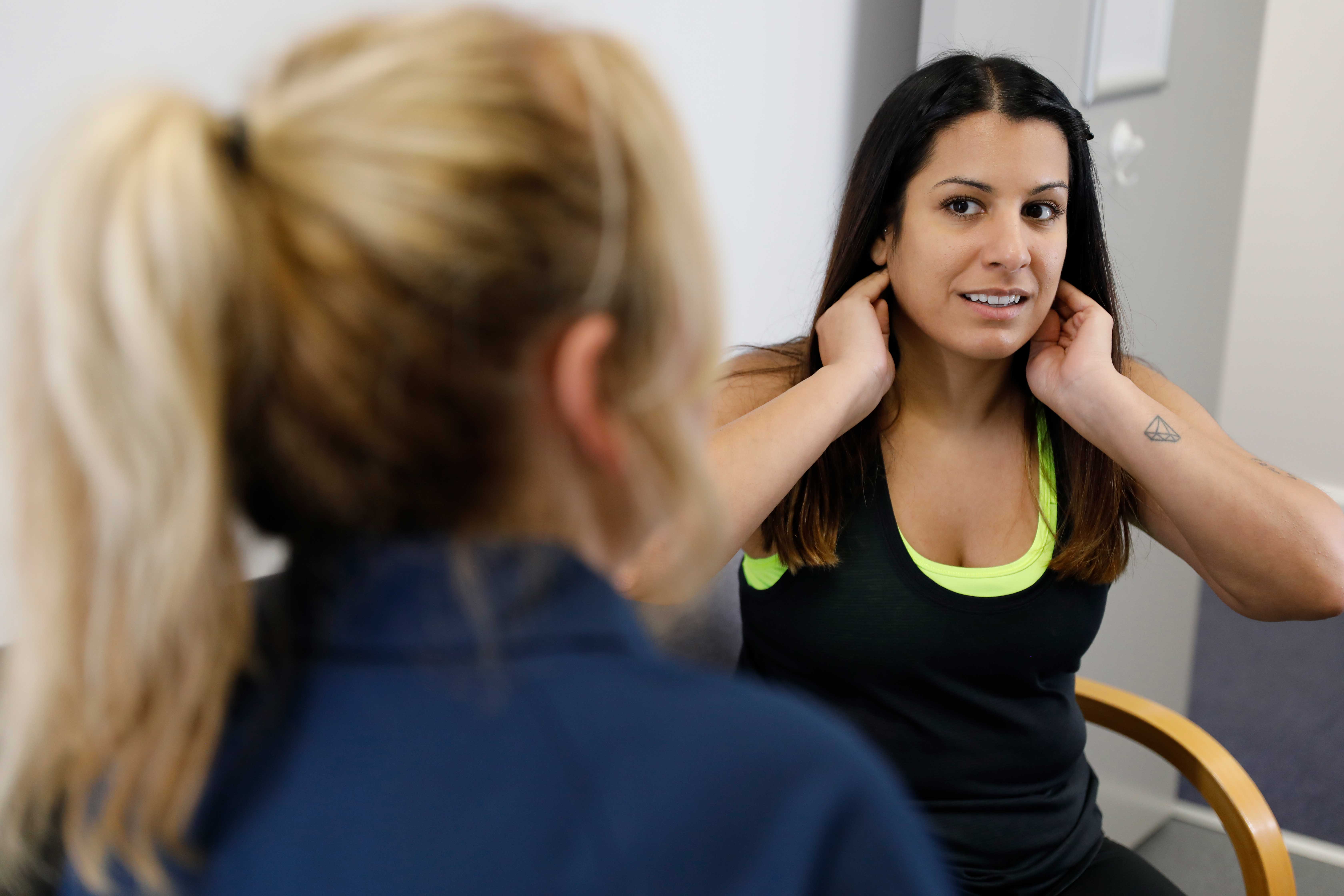 physio assessment of neck pain with young female patient and clinician