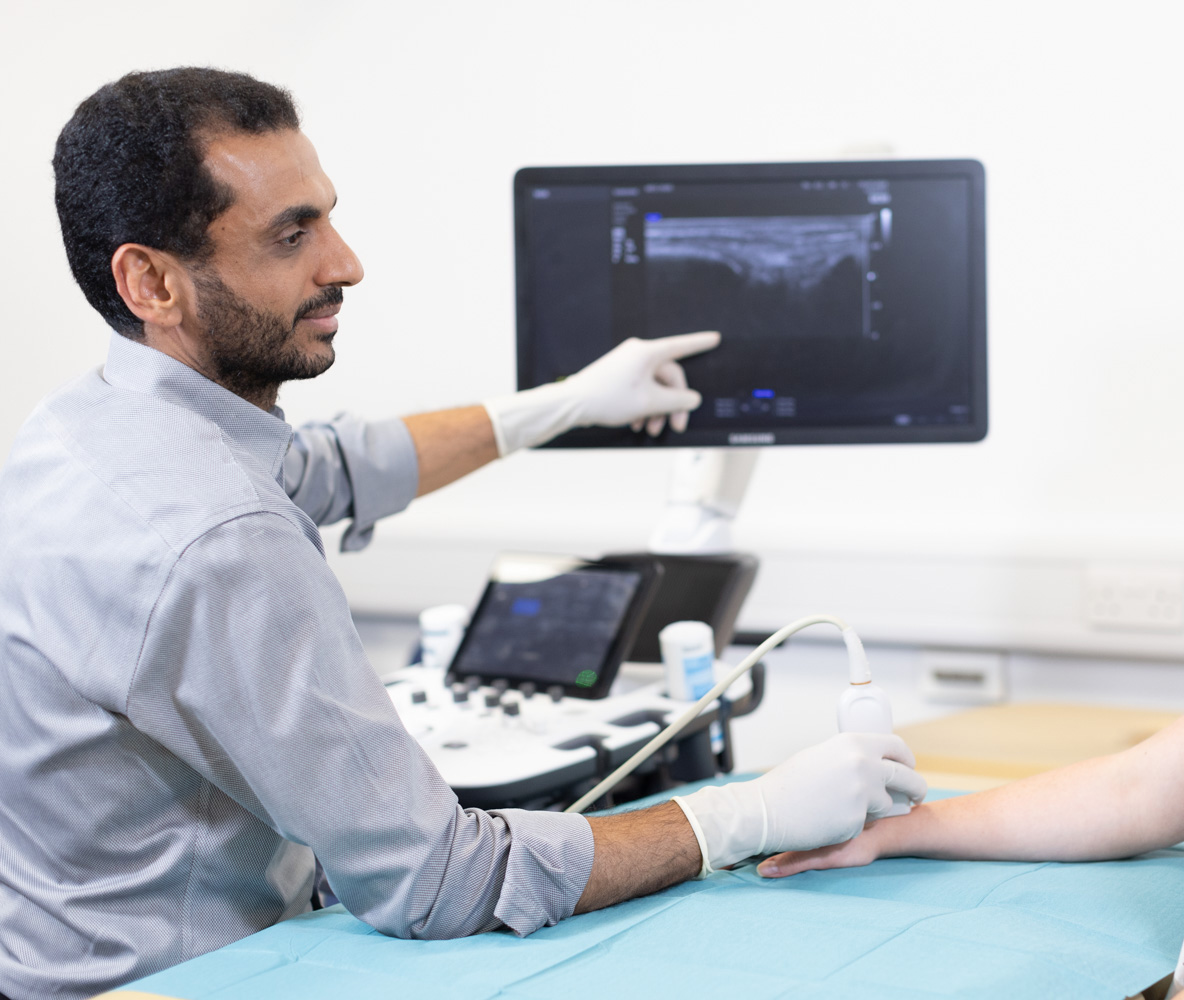 Consultant Radiologist explaining an ultrasound scan of hand to patient