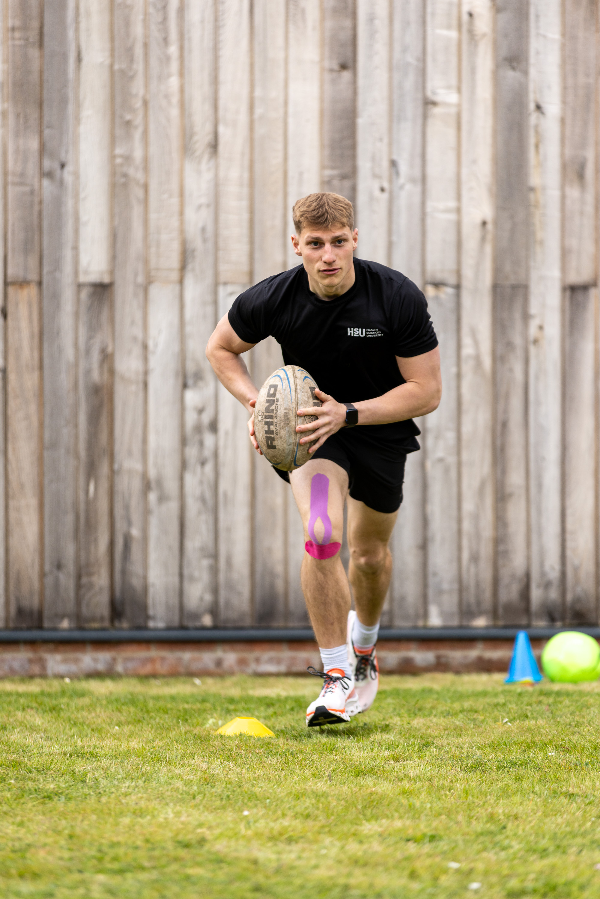 Rugby Player with tape on knee running